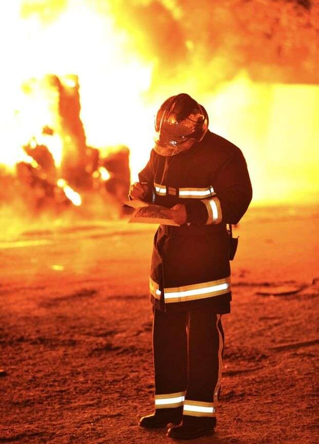 Sapeur-pompier réalisant un croquis opérationnel face à un incendie